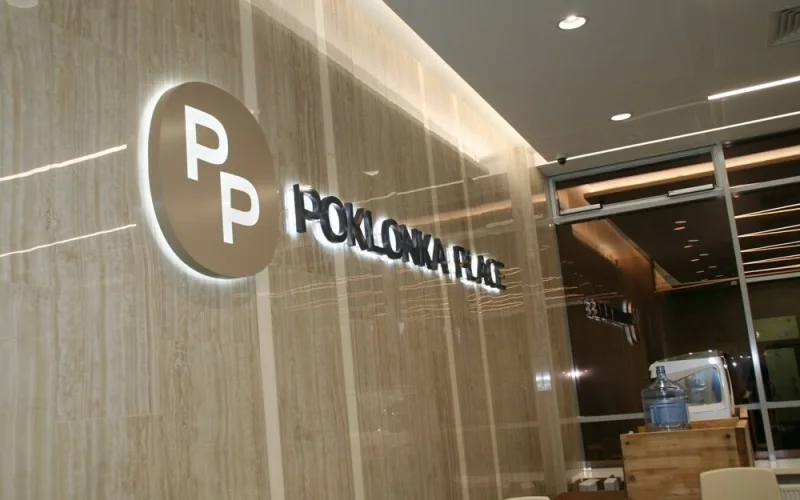 Объёмные буквы Poklonka Place и круглая эмблема PP на фактурной стене