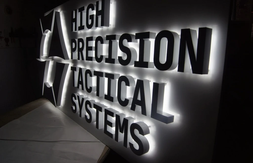 Контражурные буквы High Precision Tactical Systems в четыре строки на белой подложке