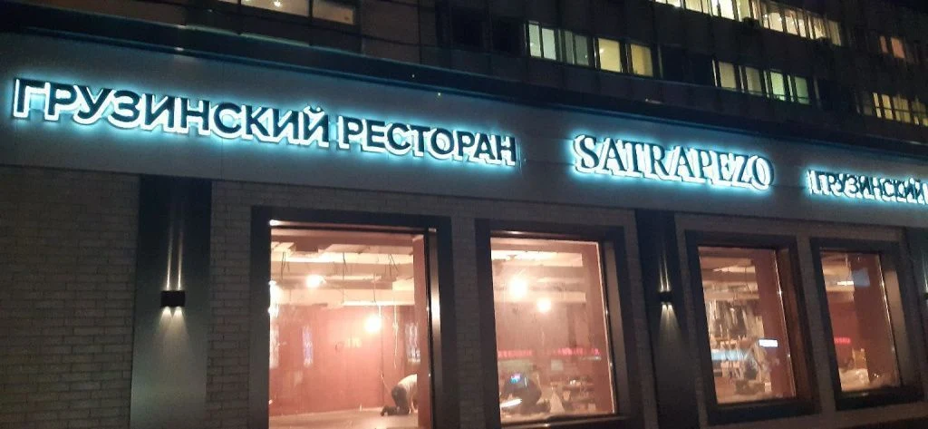Комплект вывесок Satrapezo вдоль фасада ресторана вечером