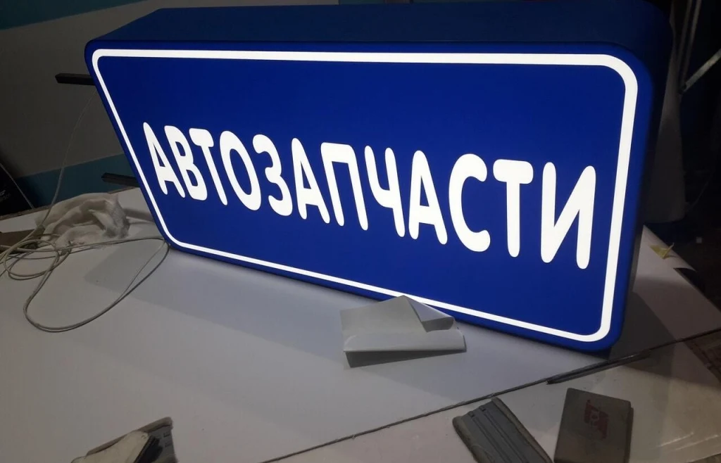 Синий лайтбокс «Автозапчасти» с белой надписью и светящимся обрамлением