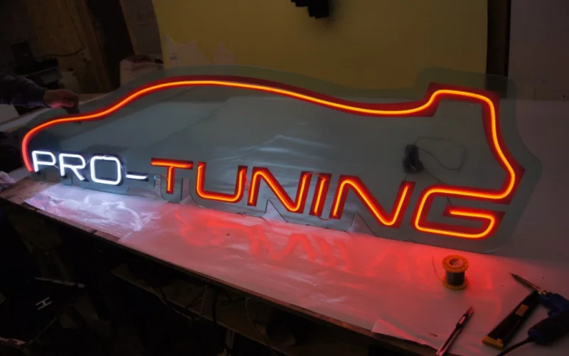 Неоновая вывеска Pro-Tuning с белой надписью PRO и красно-оранжевым автомобильным контуром