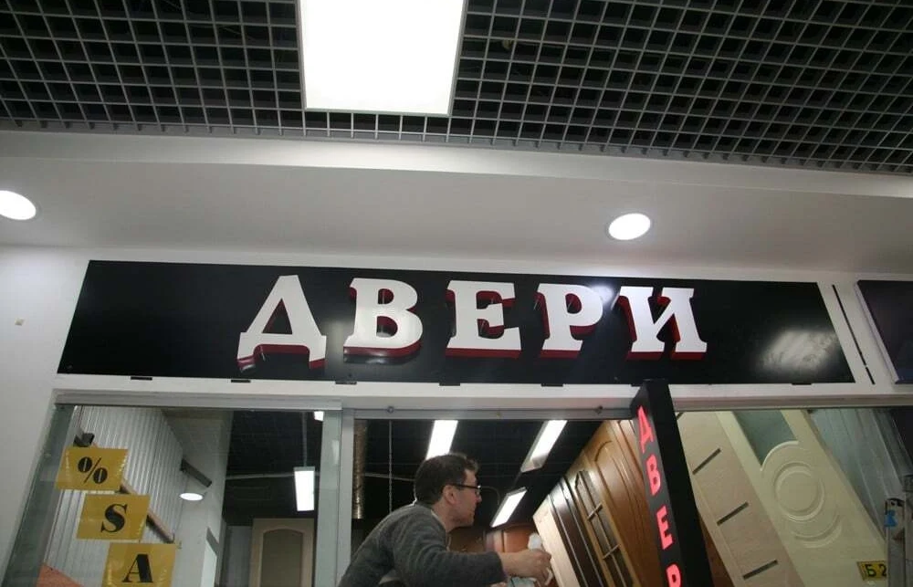Несветовые объёмные буквы «Двери» на чёрной подложке над входом в павильон