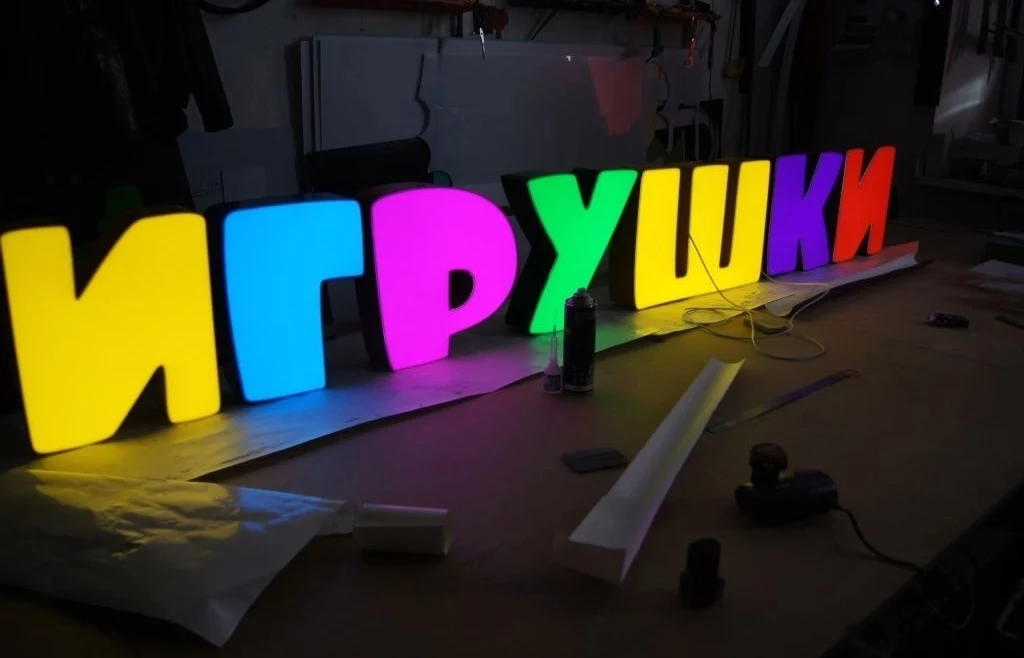 Разноцветные световые буквы «Игрушки» с включённой подсветкой в мастерской