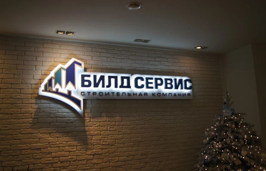 Контражурная вывеска «Билдсервис» на стене с отделкой под кирпич