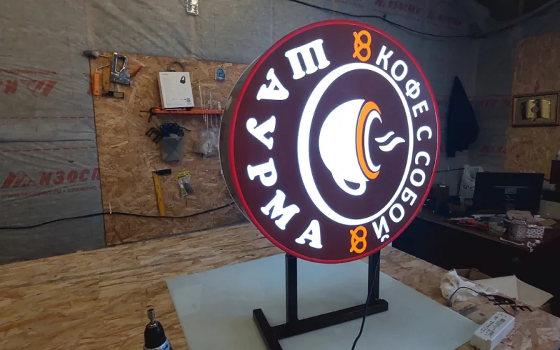 Световая круглая вывеска с чашкой, надписями «Кофе с собой» и «Шаурма»