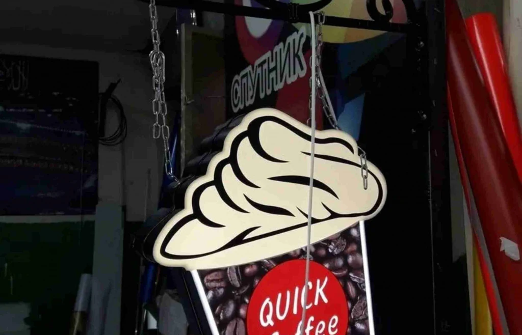 Фигурная вывеска Quick Coffee с кремовой шапкой и подвесами на цепях