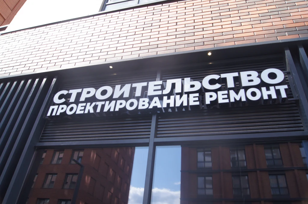 Световые буквы «Строительство. Проектирование. Ремонт» над витриной компании «Рокиос»