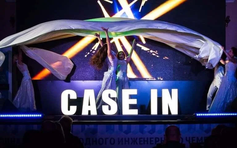 Напольная световая вывеска CASE IN перед сценой во время мероприятия