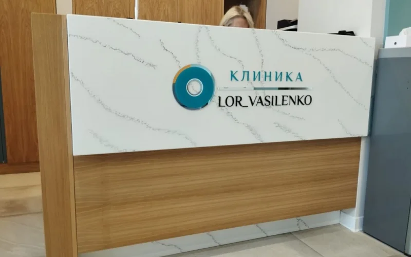 Плоские буквы и логотип клиники LOR VASILENKO на стойке ресепшн