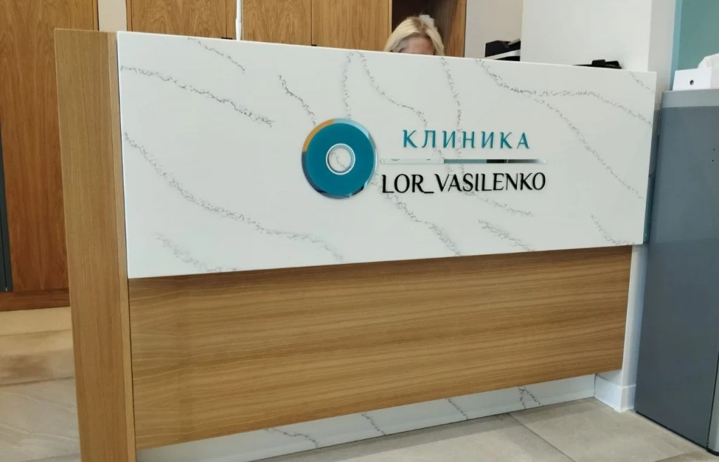 Плоские буквы и логотип клиники LOR VASILENKO на стойке ресепшн