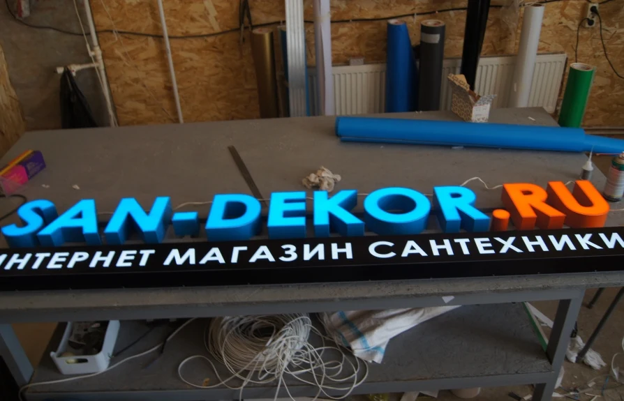 Световые буквы San-Dekor.ru и чёрный подстрочник «Интернет магазин сантехники»