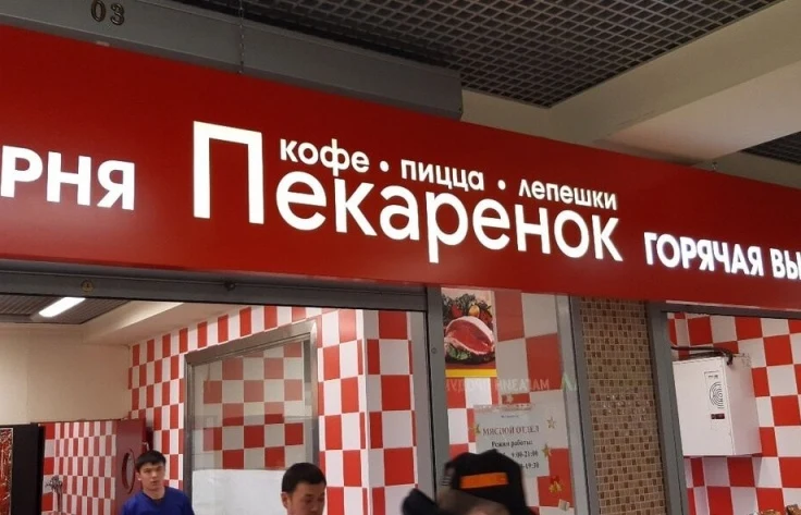 Название «Пекаренок» и строка «кофе · пицца · лепёшки» на красном коробе