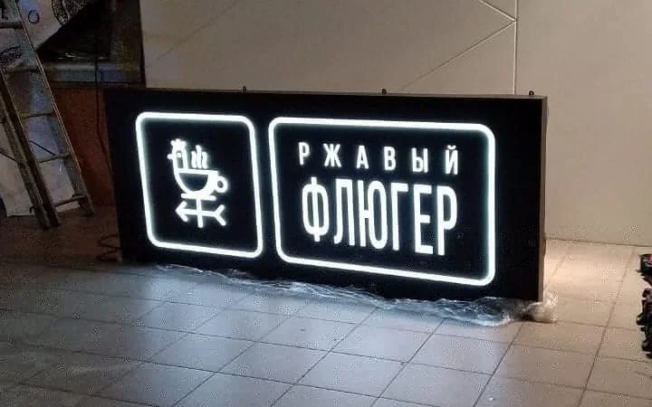 Световой короб «Ржавый флюгер» с включённой подсветкой названия и логотипа