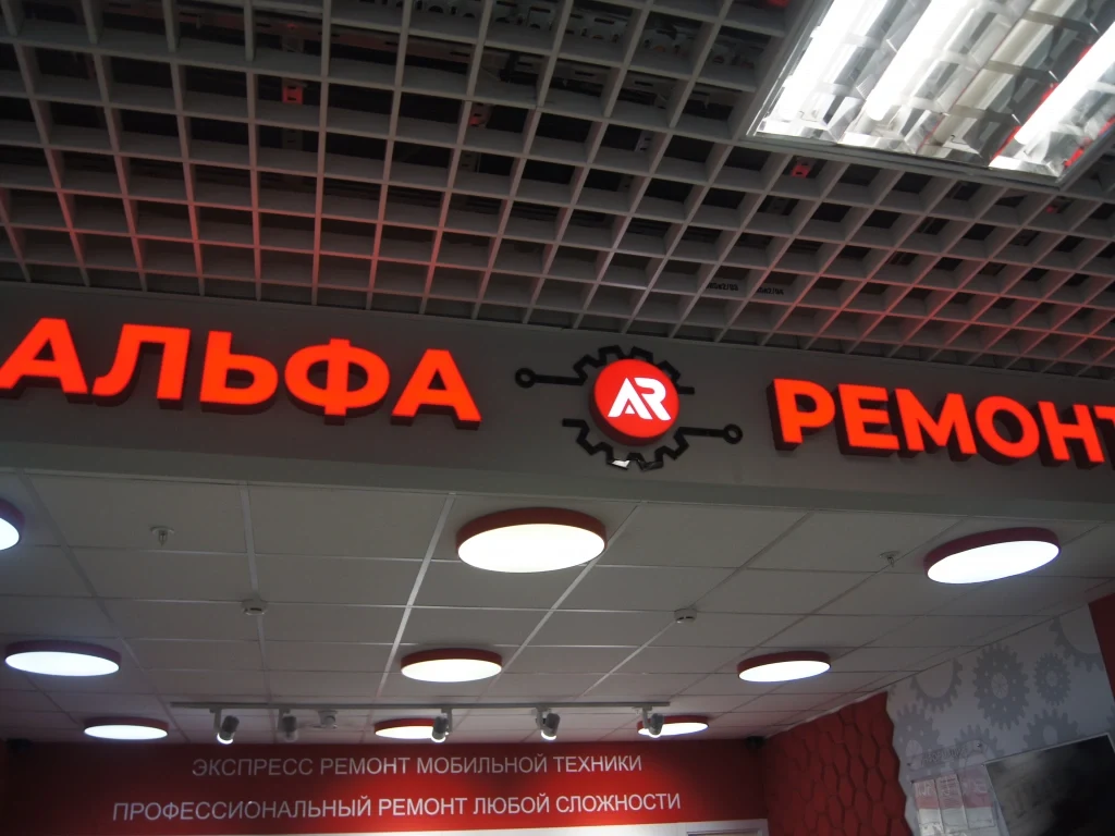 Красные световые буквы «Альфа Ремонт» и круглый логотип на сером фризе