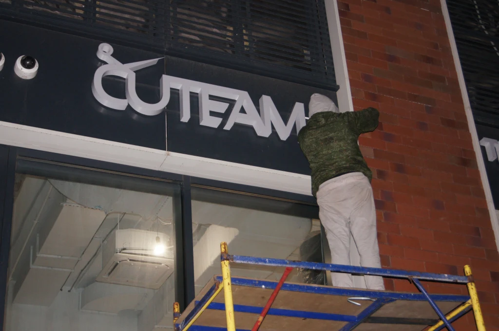 Монтаж светового логотипа Cuteam на фасаде с монтажной вышки