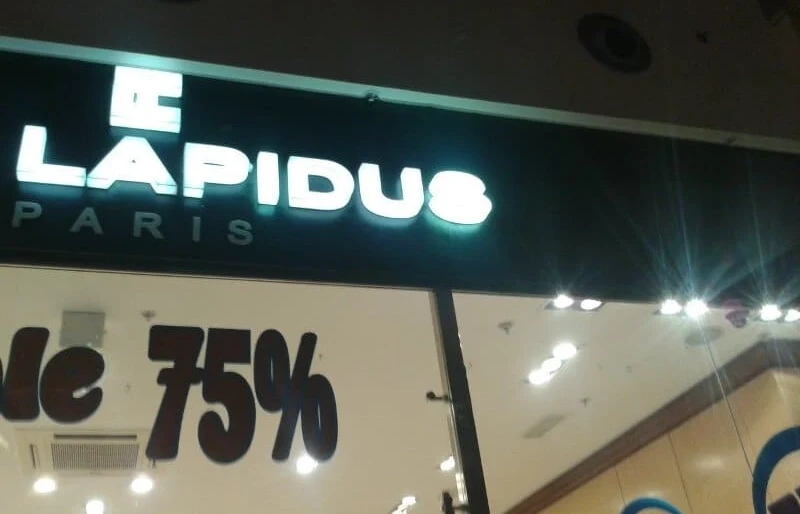 Цельносветовая вывеска Ted Lapidus на тёмном фризе магазина