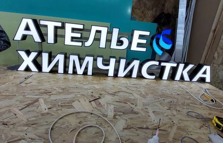 Световые буквы «Ателье. Химчистка» с чёрным обрамлением и голубым акцентом