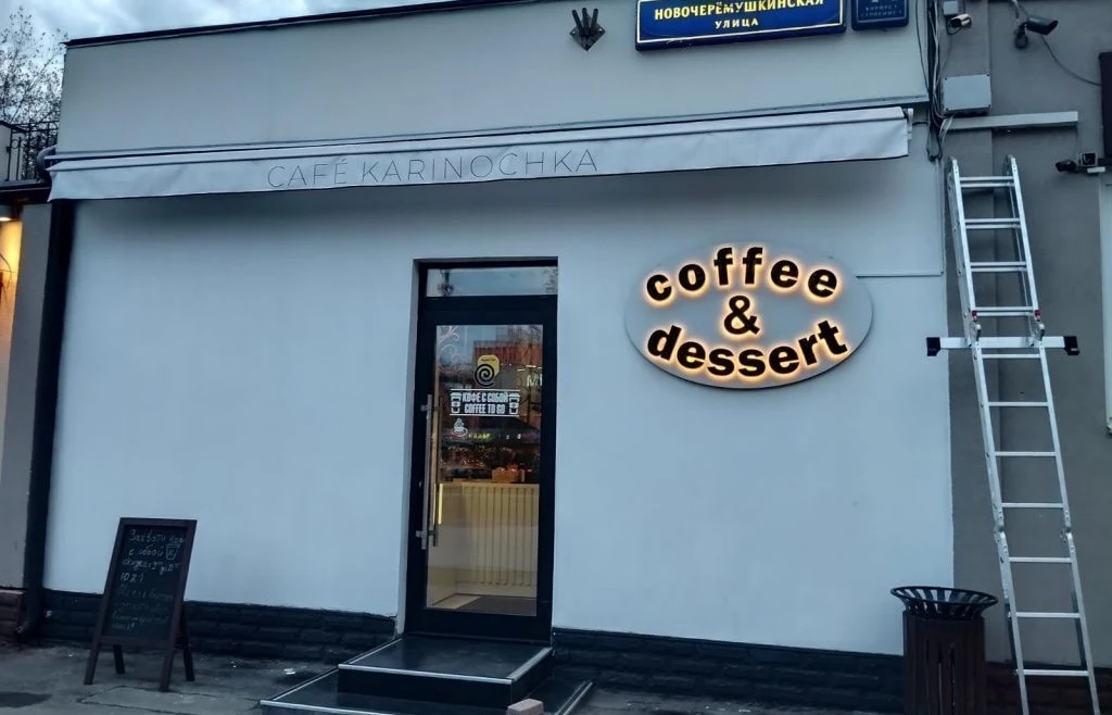 Вывеска Coffee & Dessert с тёплым контражуром справа от входа