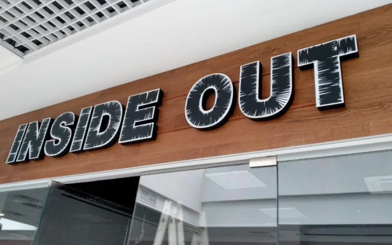 Световая вывеска INSIDE OUT над входом в магазин одежды