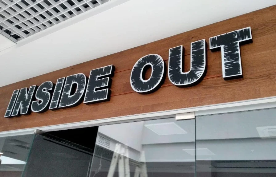 Световая вывеска INSIDE OUT над входом в магазин одежды
