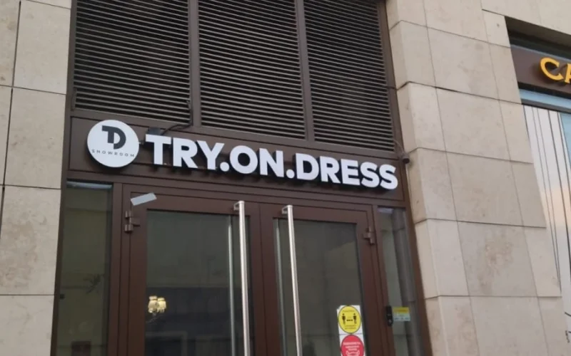 Световая вывеска TRY.ON.DRESS с круглым логотипом над входом