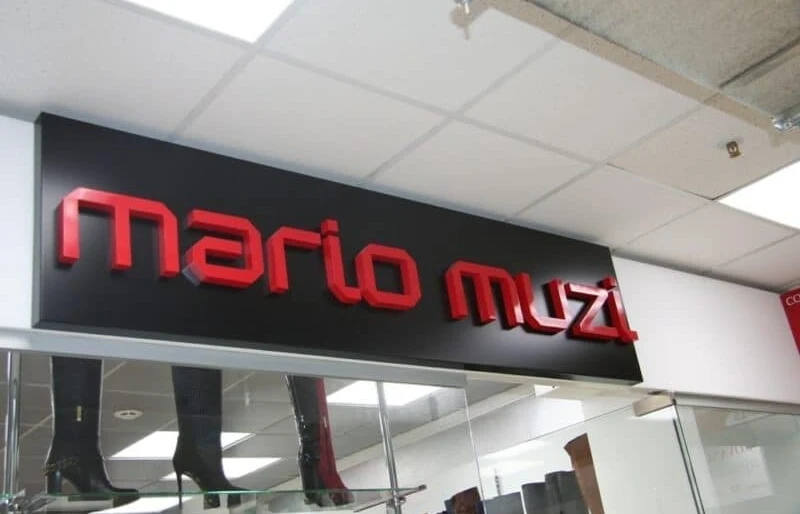 Несветовая вывеска Mario Muzi с красными буквами на чёрной подложке