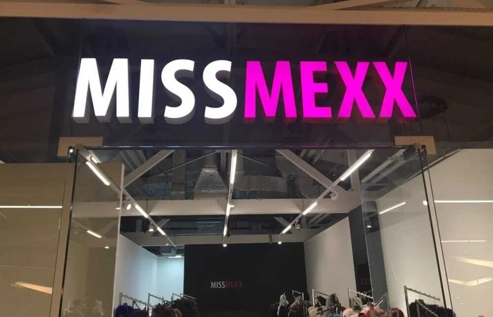Световая вывеска MISS MEXX на подложке за стеклом над входом