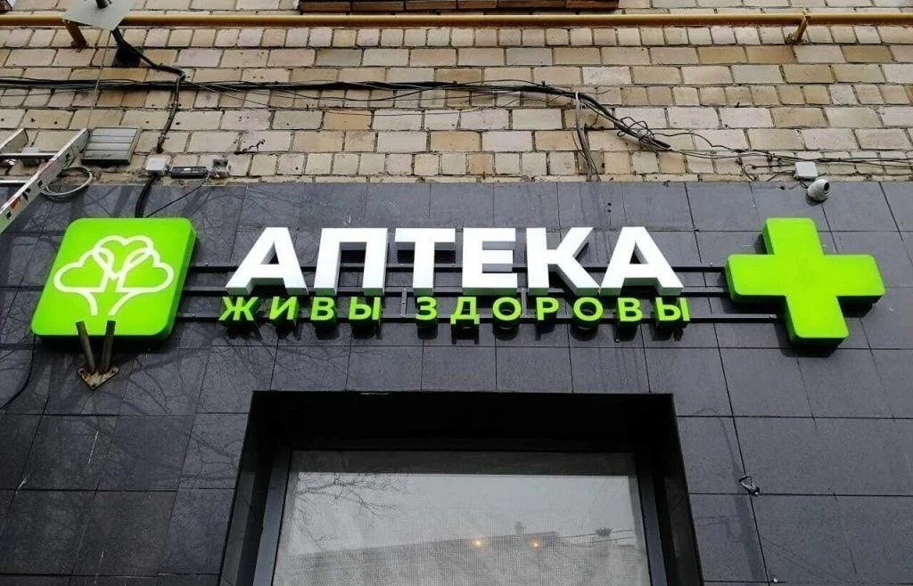 Световая вывеска «Аптека» и «Живы здоровы» над входом в аптеку